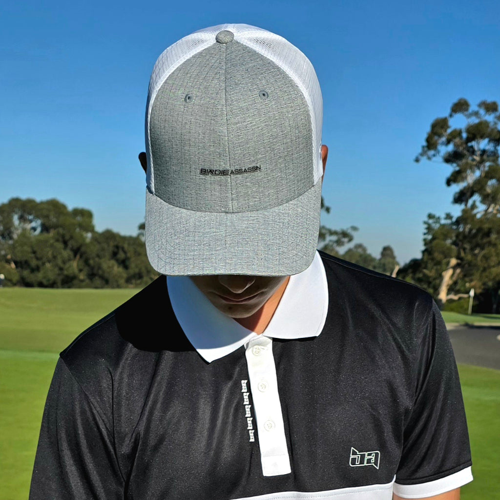 Boy wearing a Birdie Assassin Grey-White Tour Golf Cap with his head down.