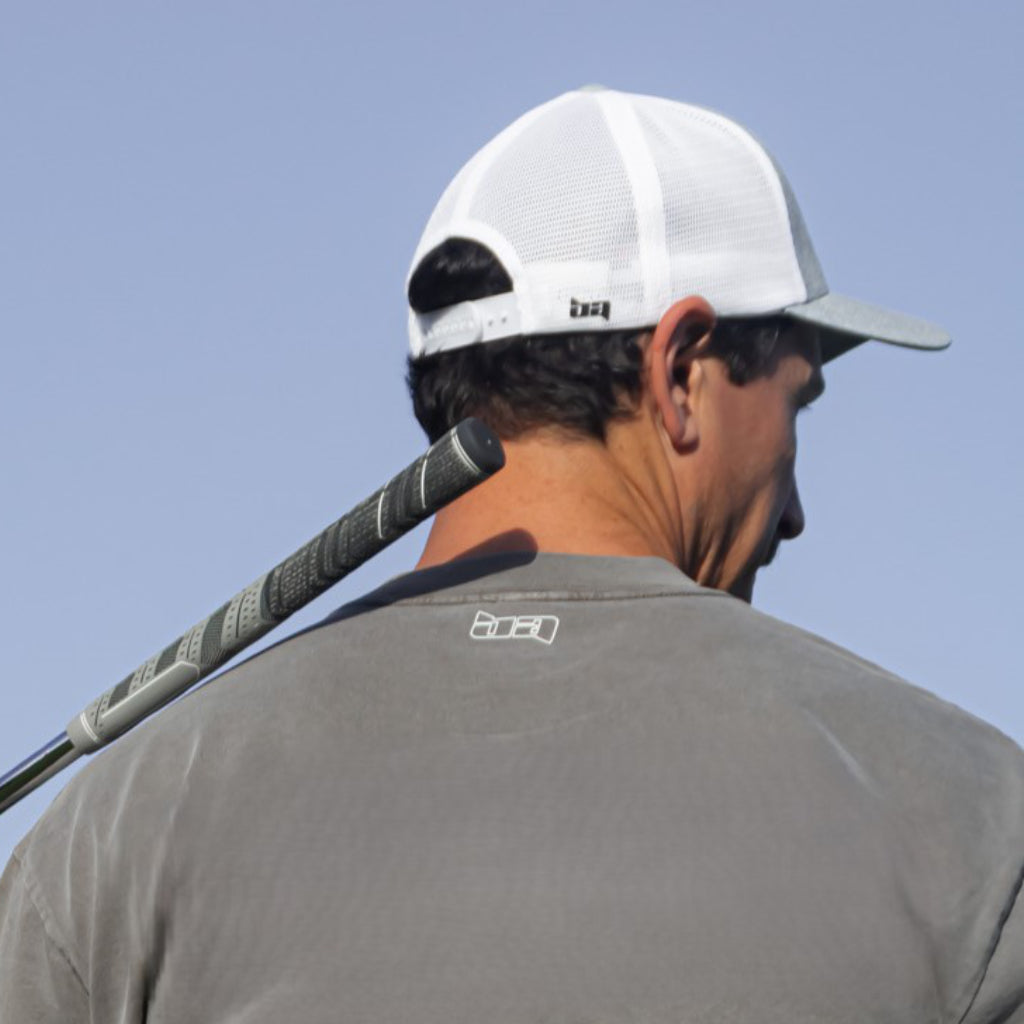 Man wearing a Grey-Whit Birdie Assassin Tour Golf Cap holding a club
