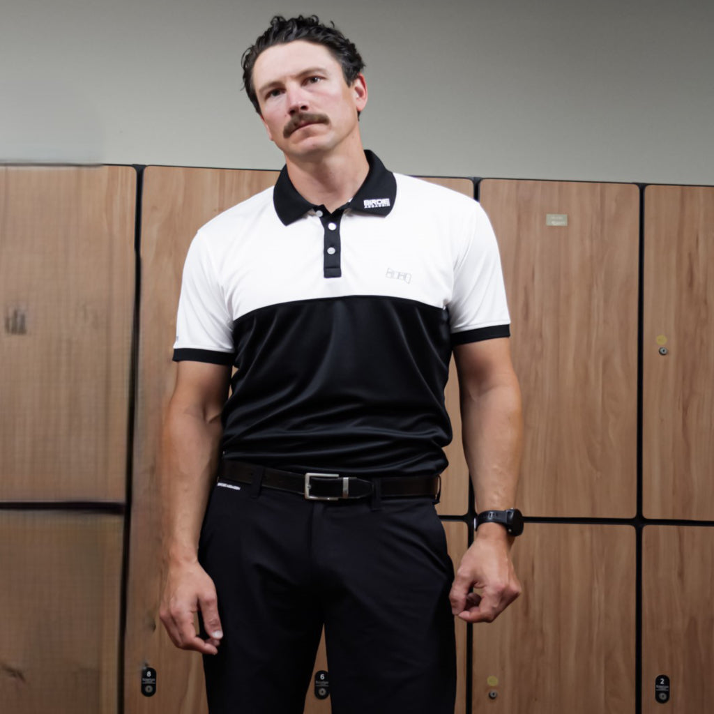 Man wearing a Bond golf polo shirt from Birdie Assassin in front of wooden lockers