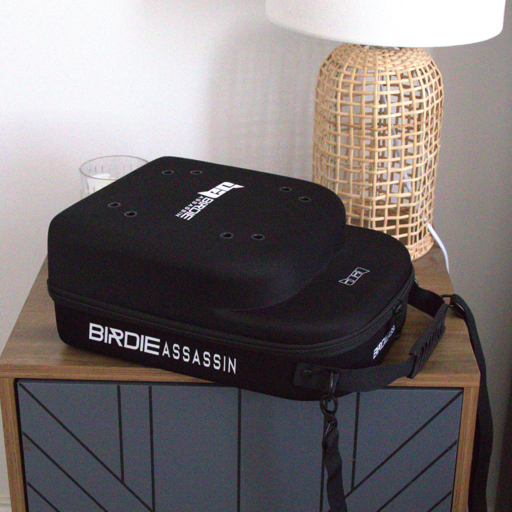 Birdie Assassin cap carry case sitting on a bedside table 