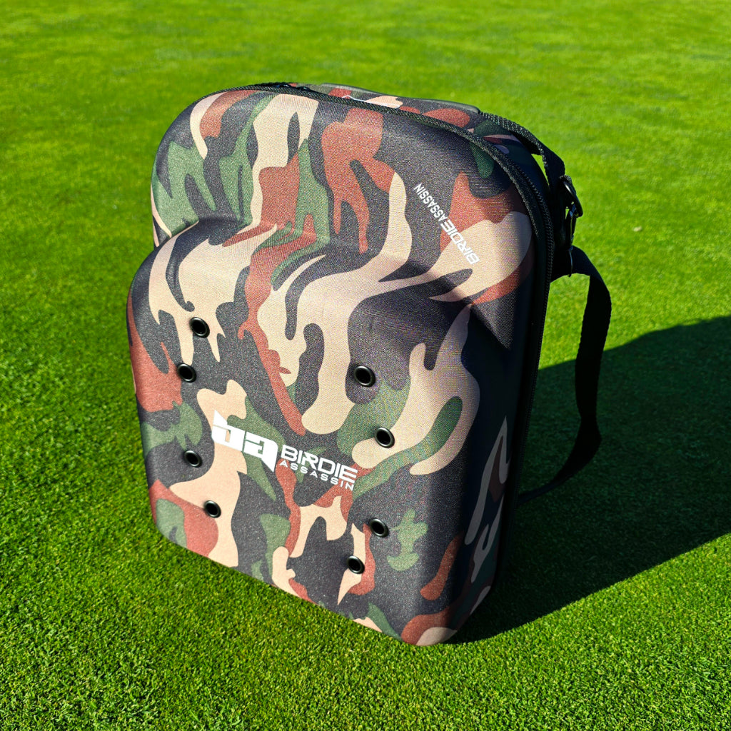 Birdie Assassin Camouflage cap carry case siting on a golf green