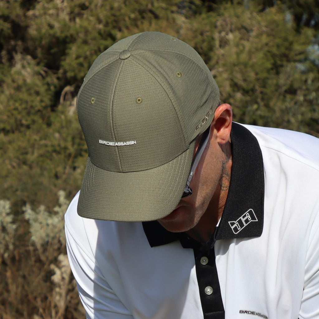 Person wearing a green Birdie Assassin Players Gol Cap looking at the ground