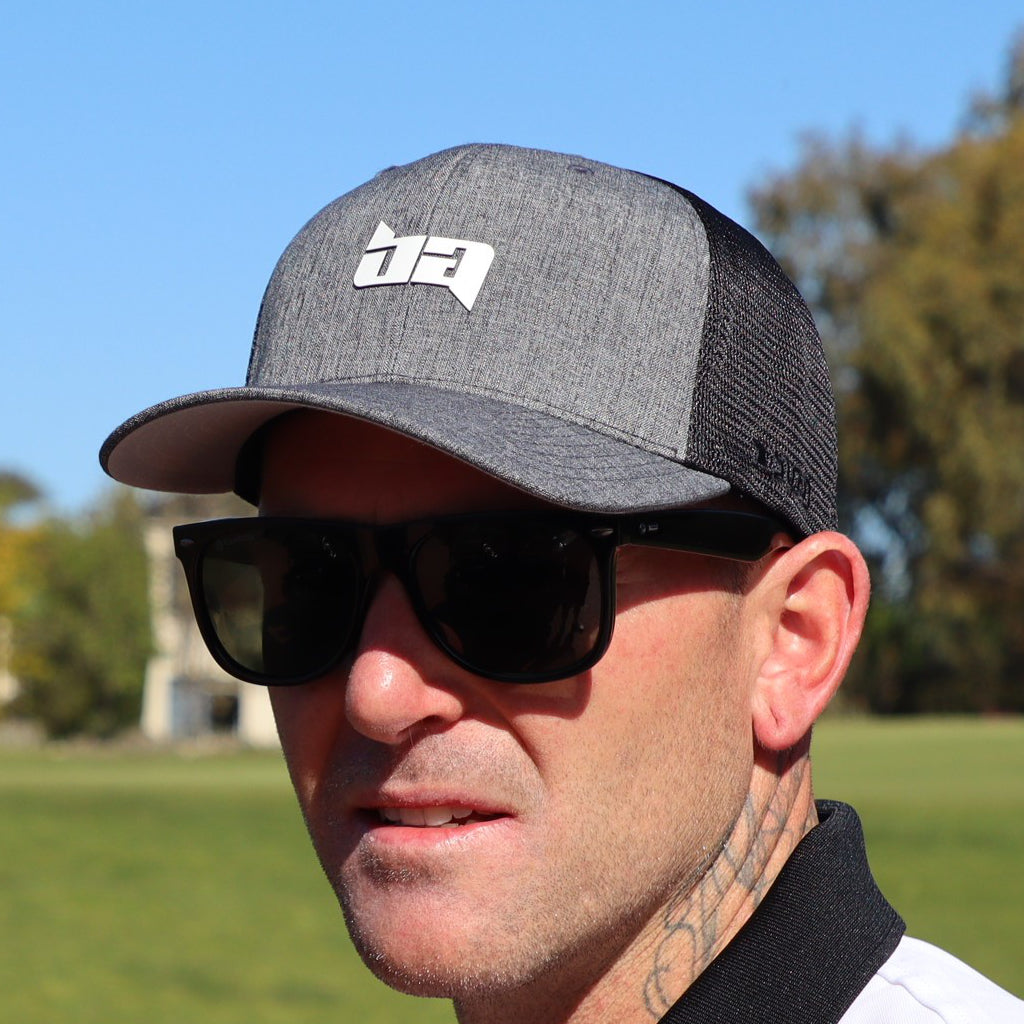 Man wearing a Tour golf cap from Birdie Assassin with a logo and sunglasses outdoors
