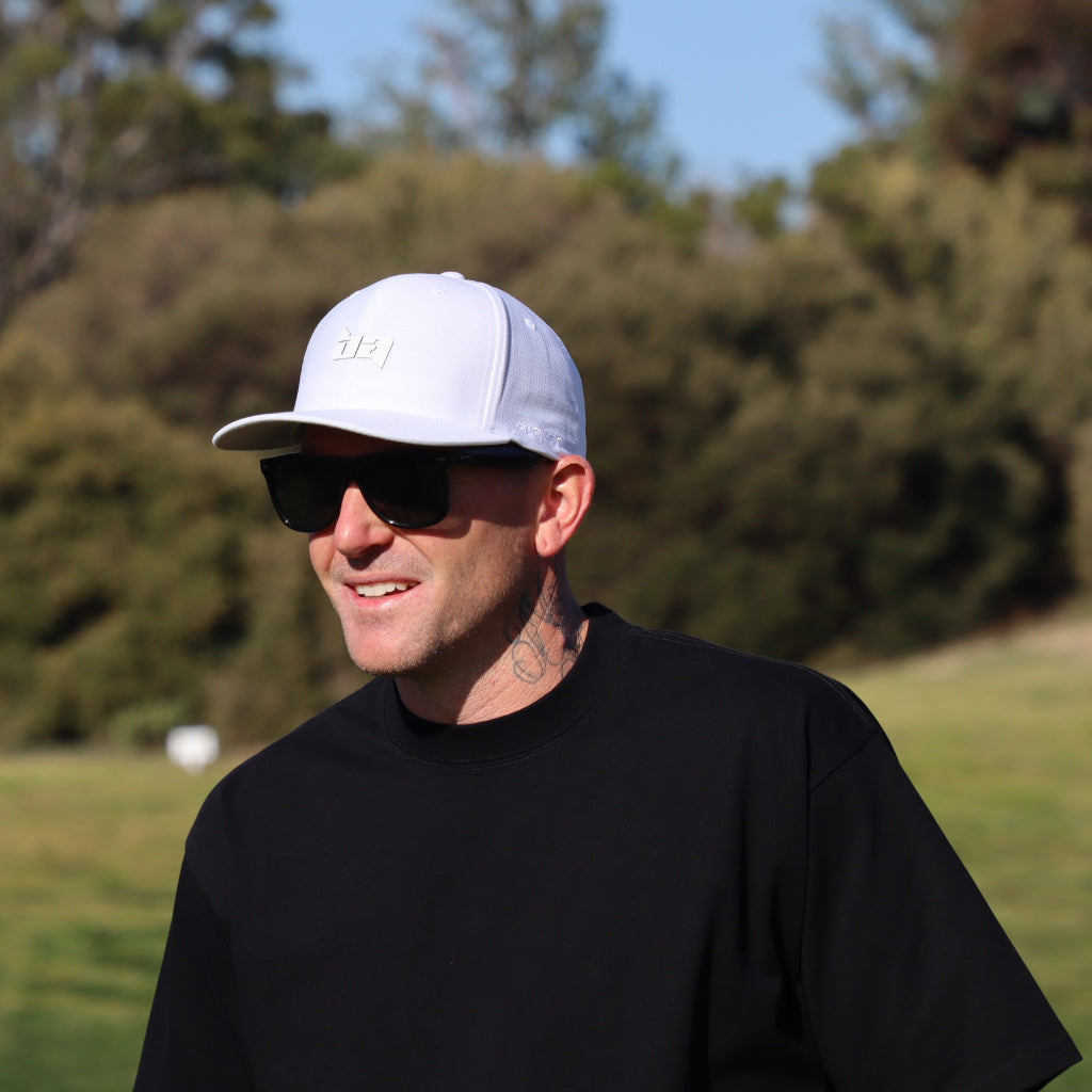 Man in a black Core golf tee from Birdie Assassin with tree n the background