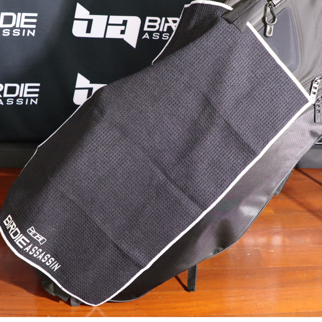 Birdie Assassin golf towel laying across a golf bag