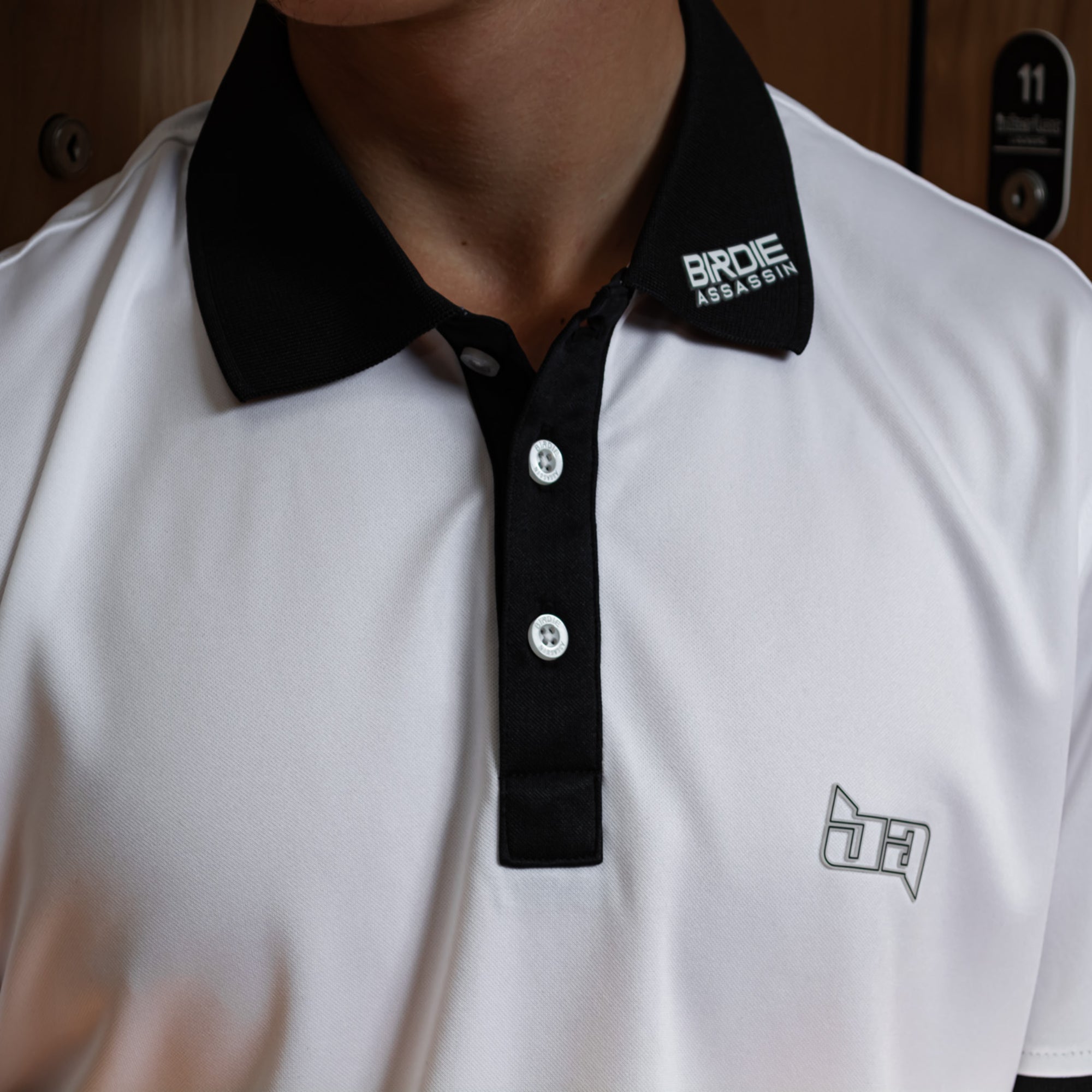 White Iceman golf polo shirt with black collar and 'Birdie Assassin' branding