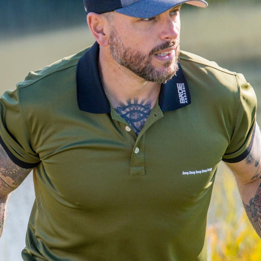 Man wearing a marksman golf polo shirt from Birdie Assassin looking over the putting green.